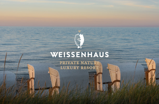 Shot of beach chairs in front of the sea in the evening and logo of Weissenhaus Private Nature Luxury Resort